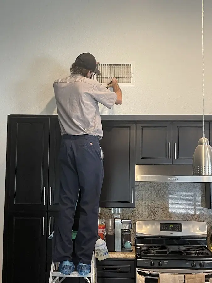 Technician inspecting an air vent during HVAC service in Lake Wisconsin